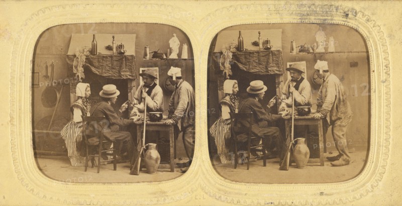 Genre scene: people in discussion around table, one woman with bonnet, gun leaning against...1860s. Creator: E Lamy.