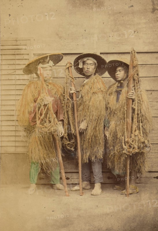 Three Japanese men in grass robes and wide-brimmed hats, 1868-1880. Creator: Felice Beato.