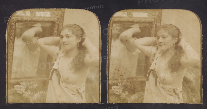 Woman before mirror with hands behind head, one breast exposed, 1855-1860. Creator: Unknown.