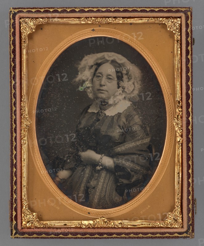 Portrait of a middle-aged woman wearing wire-rimmed glasses in flower embellished veil, 1855-1860. Creator: James McClees.