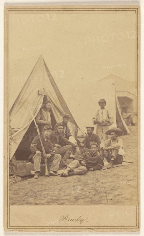 Group of seven soldiers and one black servant at a campsite, about 1862. Creator: Mathew Brady.