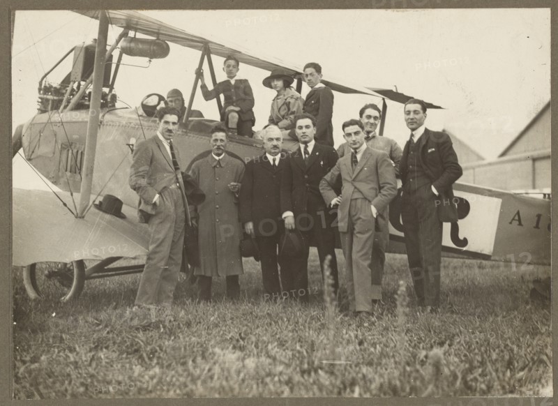 Group portrait in front of plane, 1915-1930. Creator: Fédèle Azari.