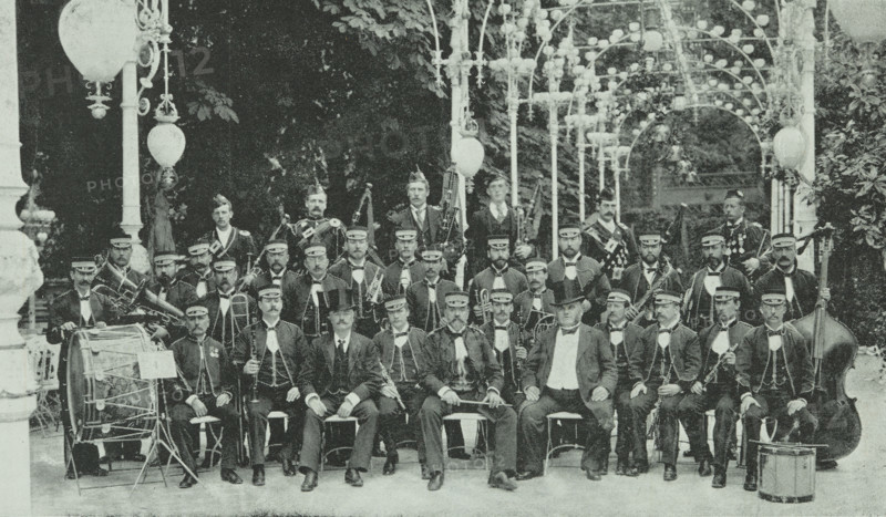 The London Military Band at Kroll's Garden in Berlin, Germany, 1896. Group portrait of British musicians in a beer garden. Instruments include: bagpipes, drums, clarinets, trumpets and a double bass.