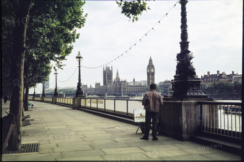 A man on the promenade on the south bank of the Thames near Hungerford Bridge, painting a picture of the view of the Houses of Parliament and Big Ben, London, 1983.