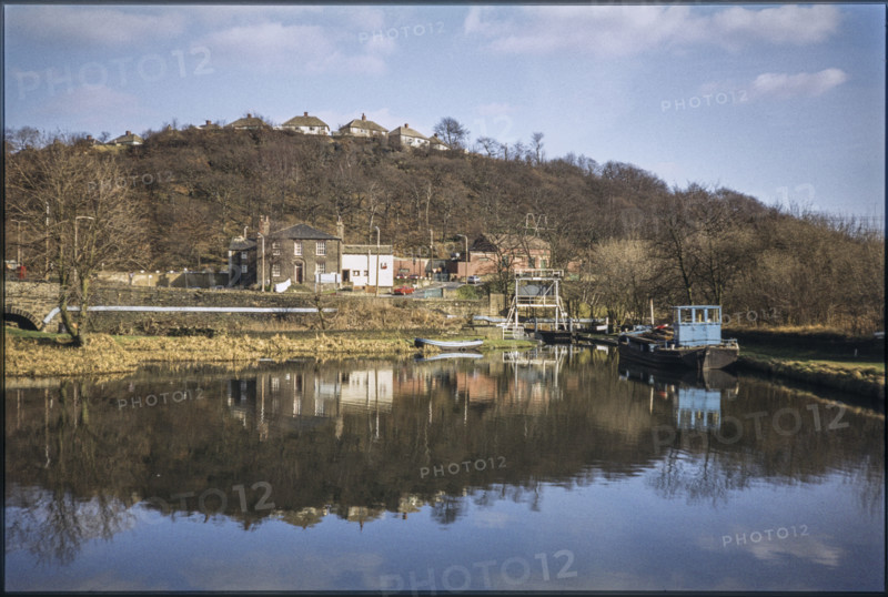 The view looking east across Salterhebble Low Basin on the Calder and Hebble Navigation, Salterhebble Low Basin, Halifax, 1980; with the Calder and Hebble Inn (now demolished) beyond the basin and homes on Chevinedge Crescent in the background.