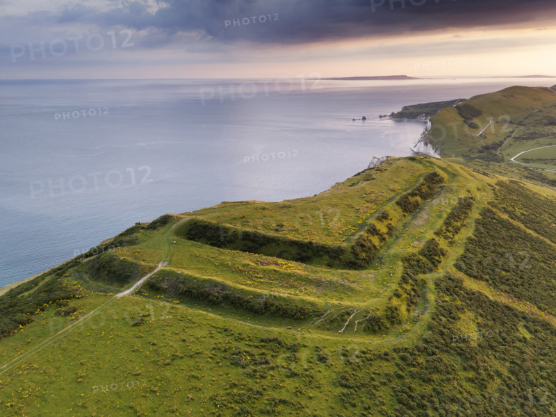 Flower's Barrow, East Lulworth, Dorset, 2024. Oblique aerial view of the hillfort from the north-east, showing how approximately a third of it has been lost to long-term coastal erosion. Drone photography.