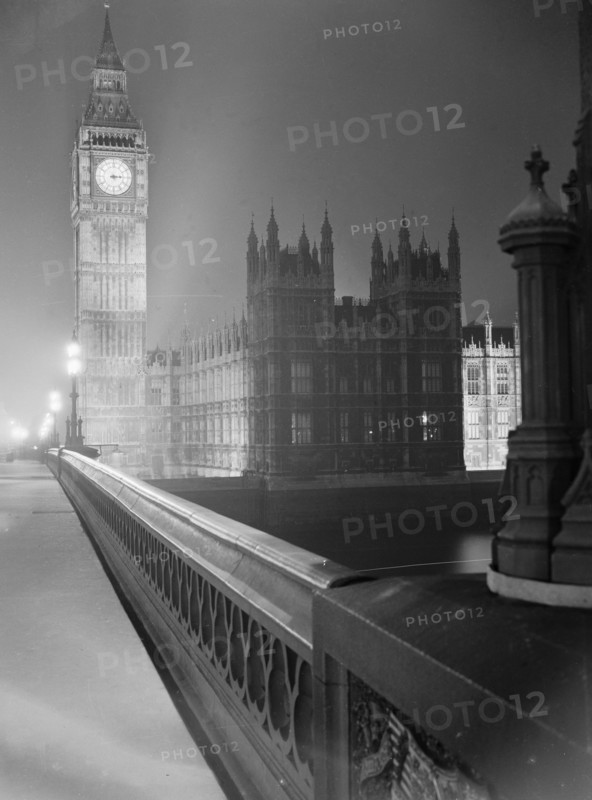 View at night along the south parapet of Westminster Bridge towards the Palace of Westminster (Houses of Parliament) and the clock tower containing the bell known as Big Ben, London, early 1960s. Image featured in London Observed by John Gay, published June 1964.