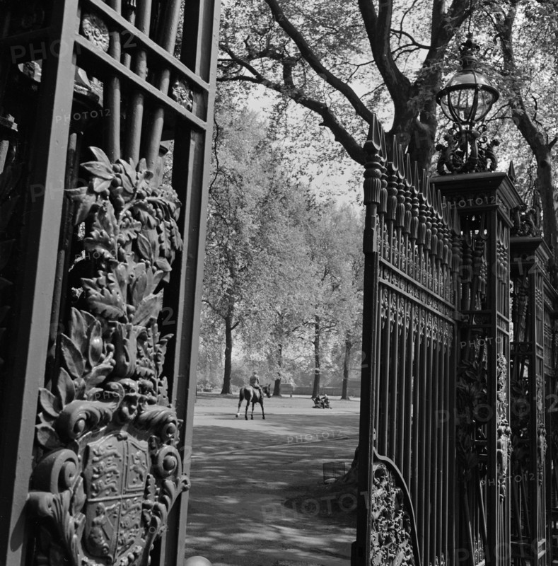 A view through one of the five pairs of elaborate cast iron gates at Queen's Gate, which leads into Hyde Park from Kensington Gore to the south of the park, 1955-1965.
