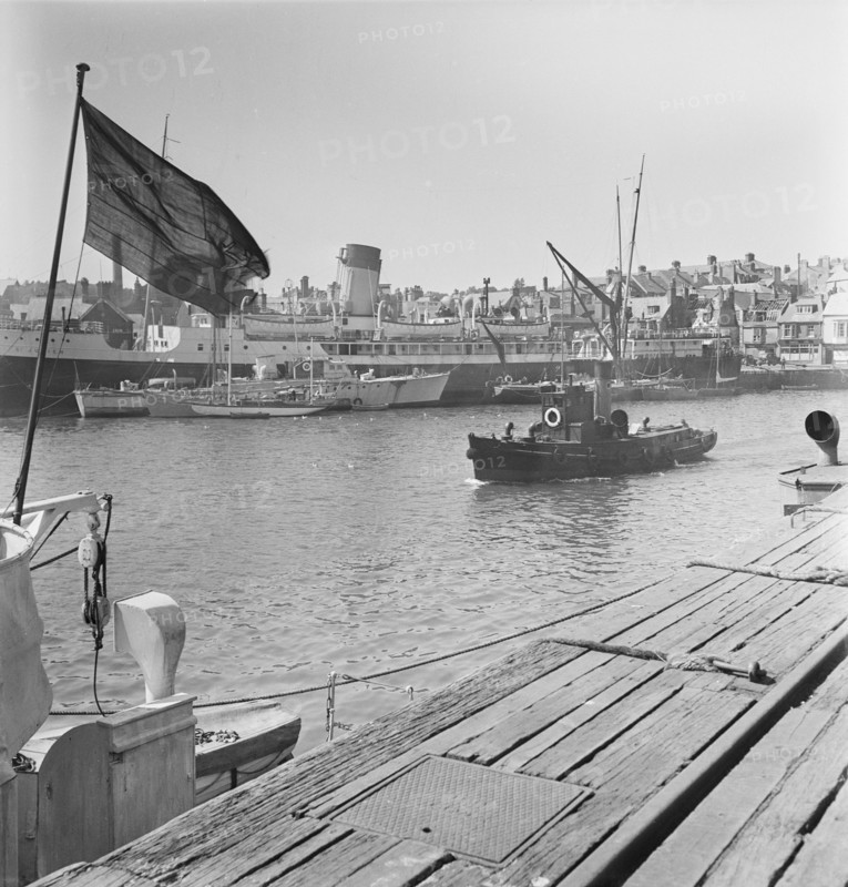 A view of the harbour at Weymouth showing various vessels including SS St Julien, 1948. This image seems to be part of a batch that were taken in preparation for a Laing staff outing to Weymouth, which was to take place on 5th June the following month. The images were published in a pamphlet which detailed the programme for the day including travel arrangements, catering and afternoon activities. The pamphlet also celebrates the fact this outing is taking place in Laing's Centenary Year, with a page dedicated to the history of the firm and another with a message from J. W. Laing.