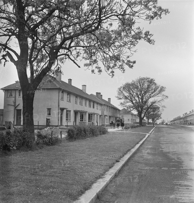 A view looking down a street of Easiform housing in Grimsby, Loncolnshire, 1948. 'Easiform' was a method of in situ pre-cast concrete construction which John Laing and Son Ltd developed from 1919 onwards. The location of this Easiform estate is not known, however it is recorded as Grimsby No.1 in the negative registers.