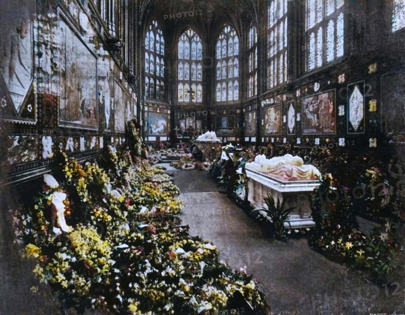 'The Albert Memorial Chapel Windsor, on the Occasion of the Funeral of H.R.H. The Duke of Clarence, January 1892', (c1897). 'The Duke's coffin stands between the tomb of the Prince Consort at the further end and that of the Duke of Albany (who died in 1884) at this end of the Chapel'. Prince Albert Victor Victor, Duke of Clarence and Avondale (1864-1892), died of pneumonia before he was thirty. The eldest son of Albert Edward, Prince of Wales (later King Edward VII), Prince Albert Victor Victor's life has been wrapped in secrecy and scandal. He is thought to have visited a male brothel, to have fathered an illegitimate child by a married woman, and was for a time rumoured to have been Jack the Ripper. From "Sixty Years A Queen: The Story of Her Majesty's Reign", by Sir Herbert Maxwell. [Harmsworth Bros, Limited, London, c1897]. (Colorised black and white print).