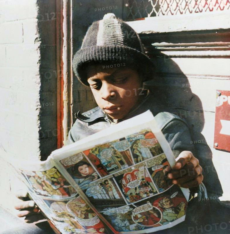 Washington, D.C. Negro youth reading a funny paper on a door step in the Southwest section. (Colorised black and white print).