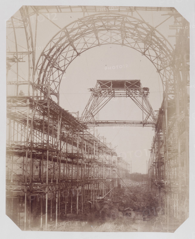 'The Nave, with intersection of the North Transept', Crystal Palace, Sydenham, 1852-1854. Designed by Sir Joseph Paxton to house the Great Exhibition of 1851 in Hyde Park, the Crystal Palace was reconstructed and enlarged in Sydenham in 1852. The first column was raised on 5 August 1852 and the palace was opened by Queen Victoria on 10 June 1854. Many exhibitions and events were subsequently held at the Crystal Palace until it burnt down on 30 November 1936. The park contained a motor racing circuit from 1937 until 1972 and the famous athletics track dates back to the foundation of the Crystal Palace Athletics Club in 1868. Plate 8 from "Photographic Views of the Progress of the Crystal Palace, Sydenham. Taken during the progress of the works, by desire of the directors, by Philip H Delamotte. Together with a list of the directors and officers of the company, etc". [London, 1855].