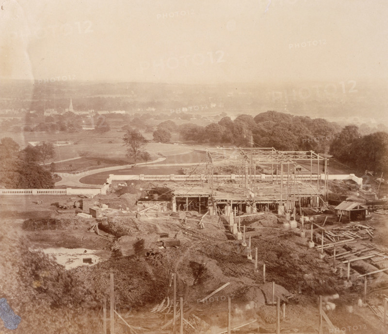 'The South Wing - seen from the Palace', Crystal Palace, Sydenham, 1852-1854. Designed by Sir Joseph Paxton to house the Great Exhibition of 1851 in Hyde Park, the Crystal Palace was reconstructed and enlarged in Sydenham in 1852. The first column was raised on 5 August 1852 and the palace was opened by Queen Victoria on 10 June 1854. Many exhibitions and events were subsequently held at the Crystal Palace until it burnt down on 30 November 1936. The park contained a motor racing circuit from 1937 until 1972 and the famous athletics track dates back to the foundation of the Crystal Palace Athletics Club in 1868. Plate 23 from "Photographic Views of the Progress of the Crystal Palace, Sydenham. Taken during the progress of the works, by desire of the directors, by Philip H Delamotte. Together with a list of the directors and officers of the company, etc". [London, 1855].