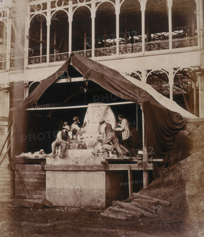 'Casting the Sphinx at the South Transept', Crystal Palace, Sydenham, 1852-1854. Designed by Sir Joseph Paxton to house the Great Exhibition of 1851 in Hyde Park, the Crystal Palace was reconstructed and enlarged in Sydenham in 1852. The first column was raised on 5 August 1852 and the palace was opened by Queen Victoria on 10 June 1854. Many exhibitions and events were subsequently held at the Crystal Palace until it burnt down on 30 November 1936. The park contained a motor racing circuit from 1937 until 1972 and the famous athletics track dates back to the foundation of the Crystal Palace Athletics Club in 1868. Plate 28 from "Photographic Views of the Progress of the Crystal Palace, Sydenham. Taken during the progress of the works, by desire of the directors, by Philip H Delamotte. Together with a list of the directors and officers of the company, etc". [London, 1855].