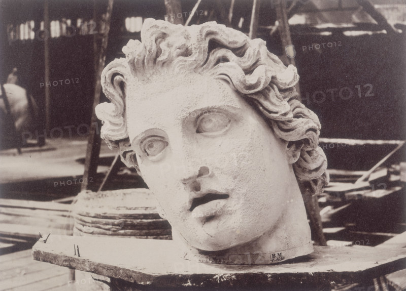 'Head from one of the Colossi of Monte Cavallo, Rome, by Phidias', Crystal Palace, 1852-1854. Designed by Sir Joseph Paxton to house the Great Exhibition of 1851 in Hyde Park, the Crystal Palace was reconstructed and enlarged in Sydenham in 1852. The first column was raised on 5 August 1852 and the palace was opened by Queen Victoria on 10 June 1854. Many exhibitions and events were subsequently held at the Crystal Palace until it burnt down on 30 November 1936. The park contained a motor racing circuit from 1937 until 1972 and the famous athletics track dates back to the foundation of the Crystal Palace Athletics Club in 1868. Plate 54 from "Photographic Views of the Progress of the Crystal Palace, Sydenham. Taken during the progress of the works, by desire of the directors, by Philip H Delamotte. Together with a list of the directors and officers of the company, etc". [London, 1855].