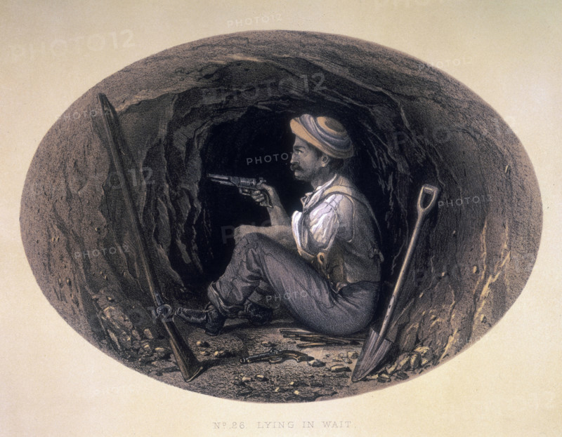 'Lying in Wait', 1858. A man armed with a pistol, sitting on the ground in what appears to be a tunnel. Another pistol lies on the ground next to him, and a rifle and a shovel are resting against the walls. From "Sketches and Incidents of the Siege of Lucknow, from Drawings made during the Siege", by George Couper.