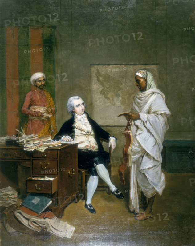 John Mowbray, Calcutta Merchant, 1790. British businessman in India. Mowbray sits at his desk which is overflowing with account books, documents and papers. He is attended by a banian, or money agent, and messenger.