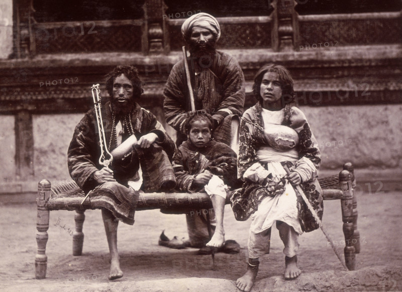 Group of beggars sitting on a charpoy, Kabul, Afghanistan, c1880.