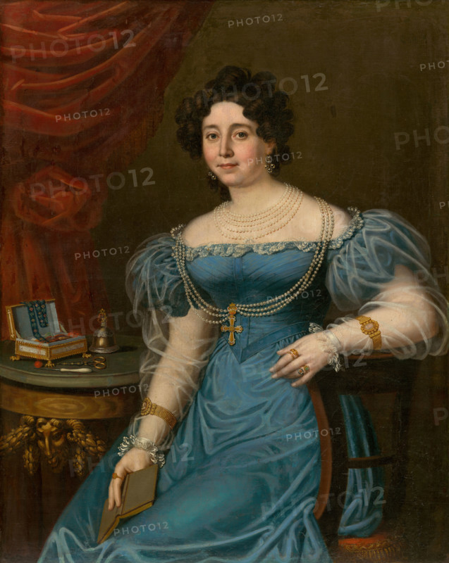 Portrait of a woman in a blue dress (Tereza Mattyásovszká, née Bydesházyová), 1827. Woman in a lace-trimmed dress, holding a book. She wears pearl necklaces and gold bracelets. On the table is a sewing box with scissors and thread, and a bell for summoning servants.