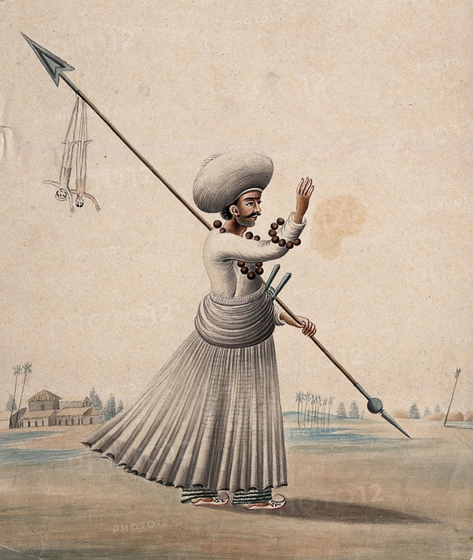 A man holding a long arrow with two puppets (?) hanging from it, (between 1800 and 1899?). Creator: Unknown.