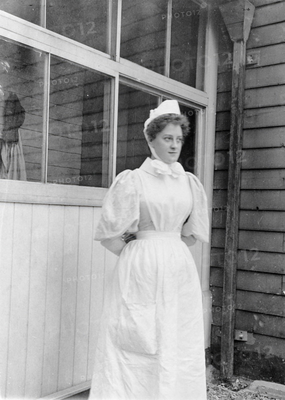 Nurse standing outside an isolation hospital, possibly at Ilford, Essex. Creator: Unknown.
