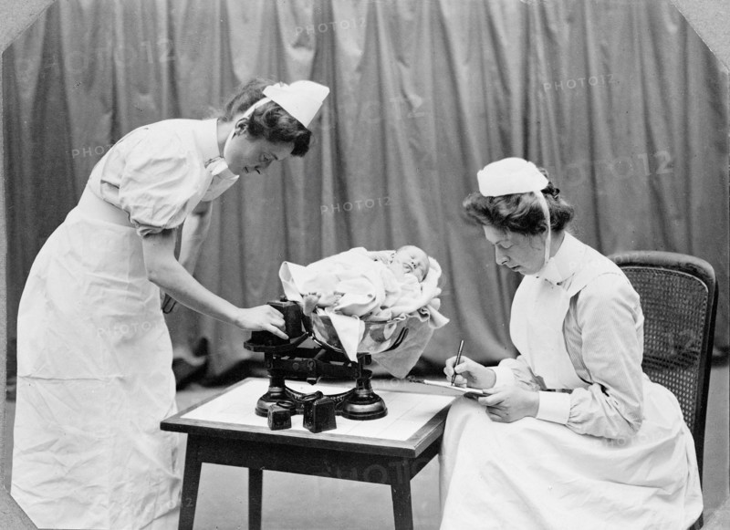 General Lying In Hospital, York Road, Lambeth: nurses weighing a baby, 1908. Creator: Unknown.