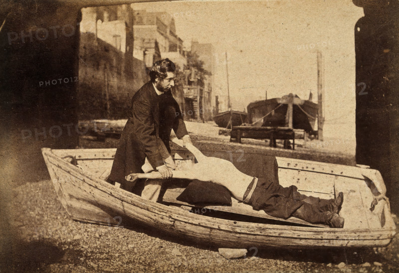A man and a boy with bare torso in a rowing boat grounded on a beach..., c1860s. Creator: Unknown.