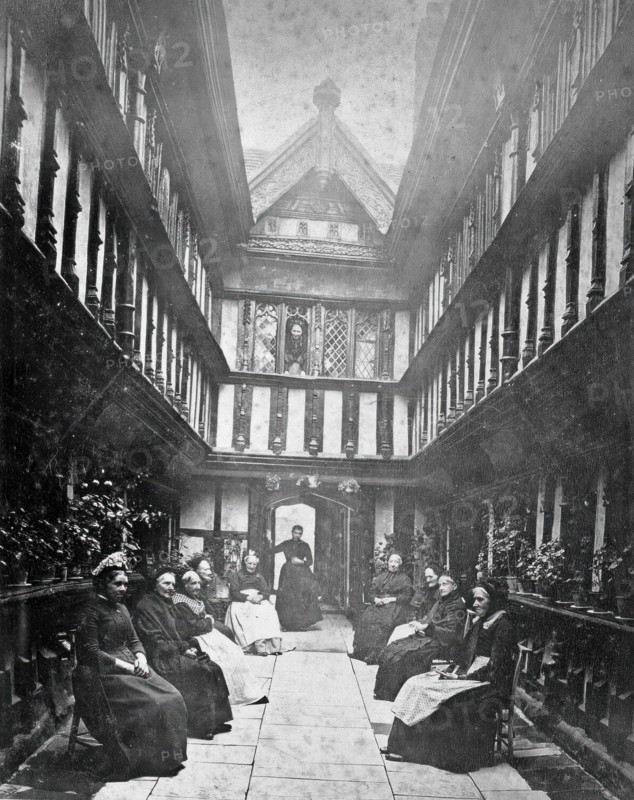 Ford's Hospital, Coventry: residents seated in the courtyard looking toward the street, c1880s. Creator: Unknown.