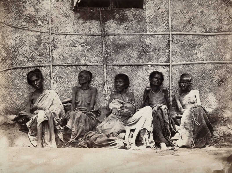 Famine in Mysore, India: six emaciated women, five sitting and one leaning on another's lap, 1876-78 Creator: Willoughby Wallace Hooper.