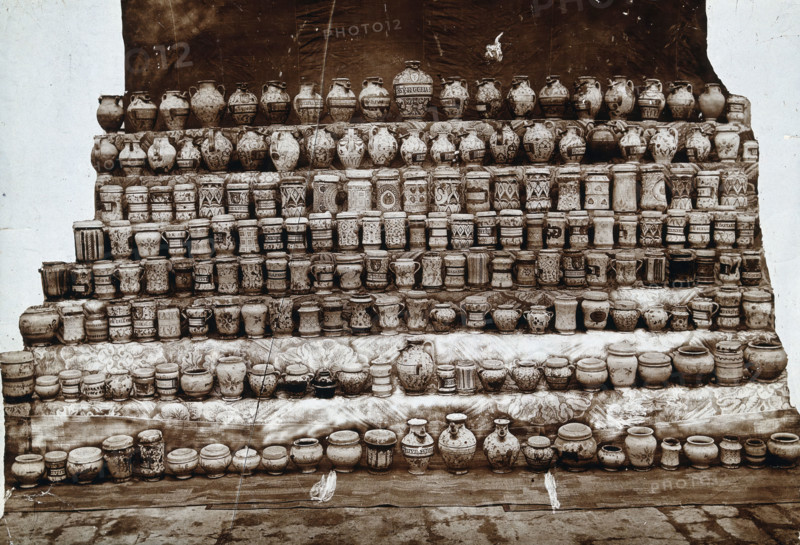 Rows of decorated pharmacy jars and other objects, c19th century. Creator: Unknown.