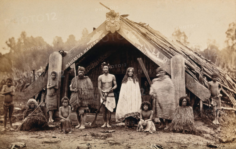New Zealand: a group of Maori in front of a traditional building, 19th century. Creator: Unknown.