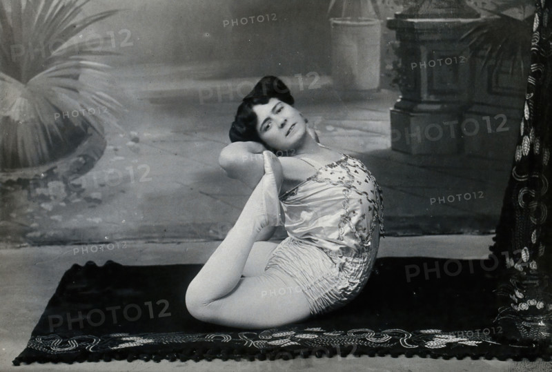 A Bulgarian female acrobat performing contortions in a photographic studio, between 1890 and 1910. Creator: Unknown.