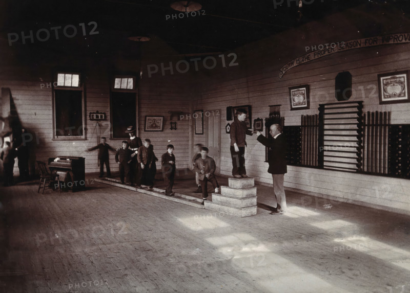 Metropolitan Lunatic Asylum, Kew, Victoria (Australia): boys walking along a ladder laid upon... Creator: Unknown.