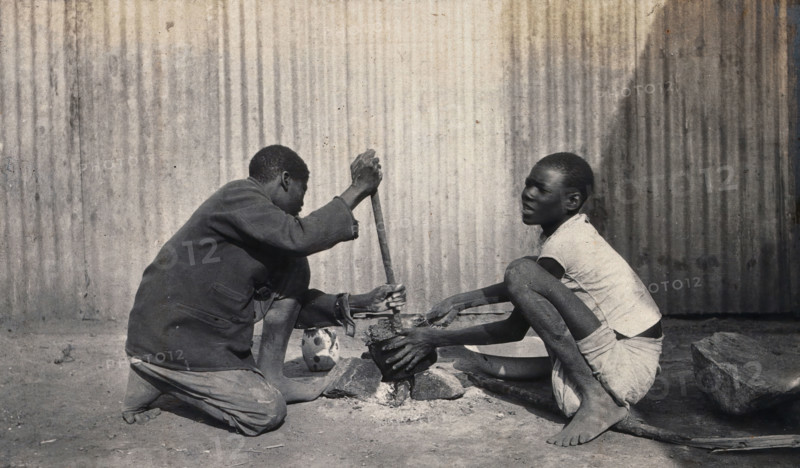 Umtali, Zimbabwe: two African boys stirring a cooking pot, 1905. Creator: J Lomas.