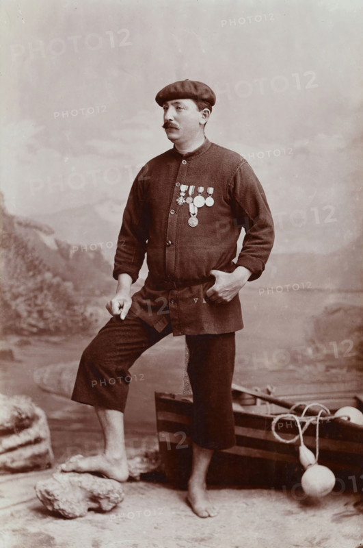 A barefoot Basque fisherman posing with several medals on his tunic, undated, estimated c1900s. Creator: Unknown.