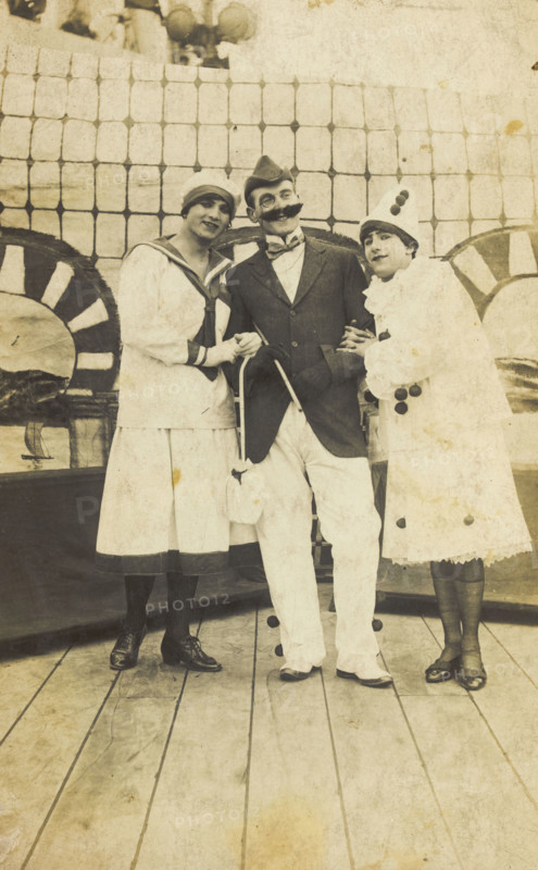Three sailors, two in drag wearing pierrette costumes, pose on deck, c1910s. Creator: Unknown.