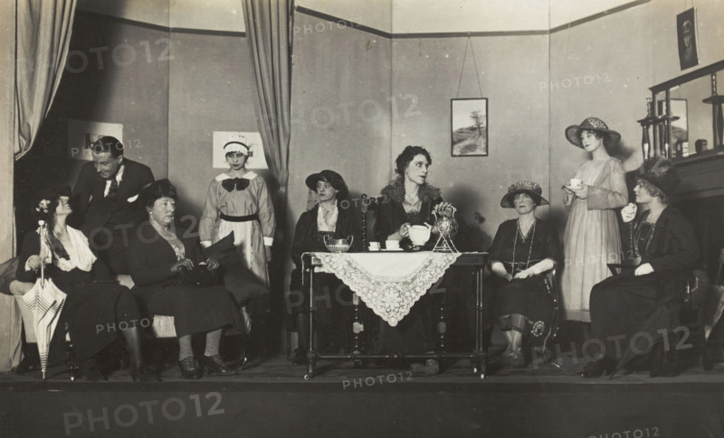 Amateur actors, some in drag, are having tea on stage, [between 1920 and 1929?]. Creator: Unknown.