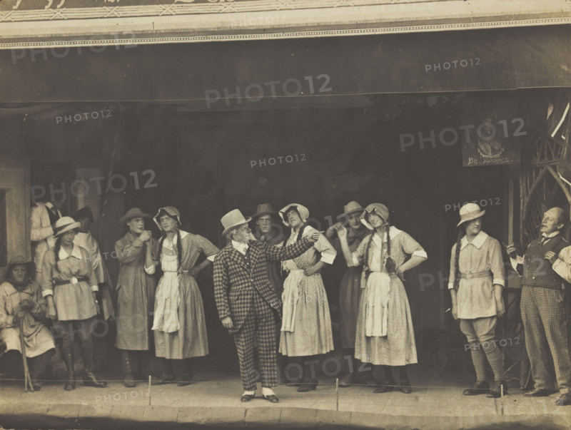 Sailors, some in drag, stand on stage performing a scene, (between 1910 and 1919?). Creator: Unknown.
