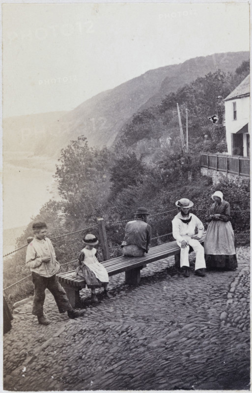 People gathered by the bench at the Lookout in Clovelly, 1860s. Creator: Unknown.