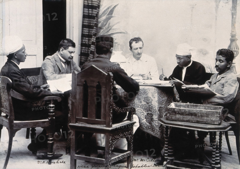 A group of men taking notes at a table, during a plague epidemic in Mandalay, 1906. Creator: Unknown.