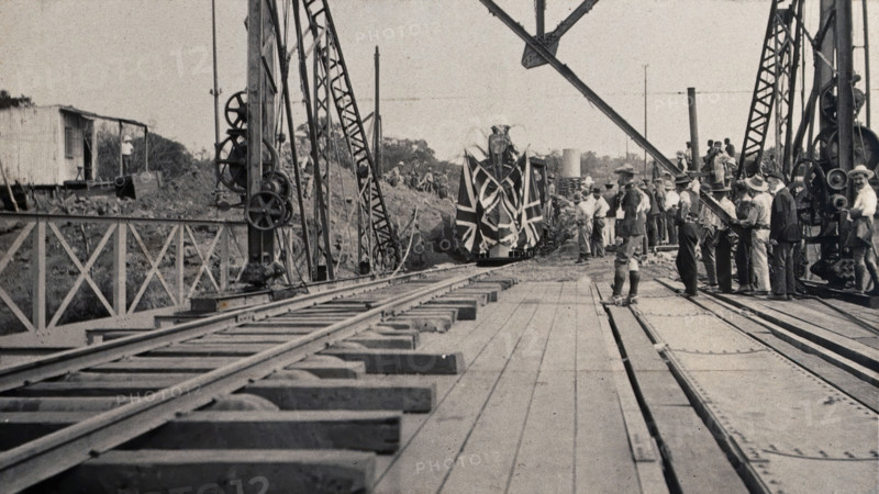 Zimbabwe: people and a flag-covered train at the opening of Victoria Bridge, 1905. Creator: J Lomas.