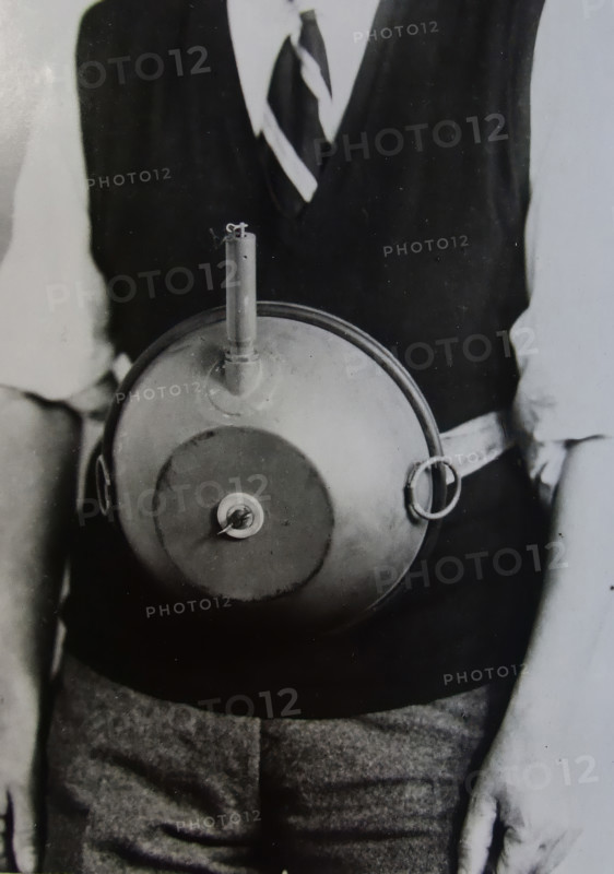 Cecil Vandepeer Clarke wearing an early version of the limpet mine on a keeper plate, c1939.  Creator: British Government.