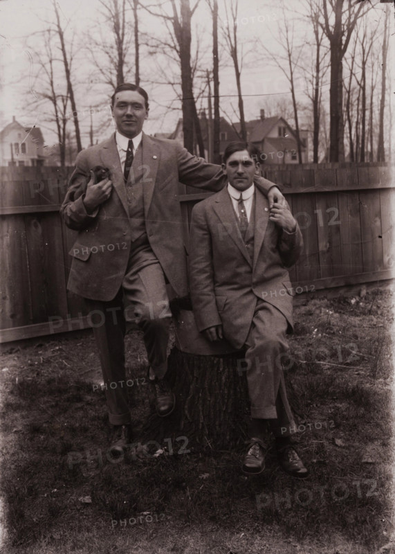 Untitled (two men holding small dog; one sitting on a stump, Fisher St., backyard), c1915. Creator: Wendell Hotter.