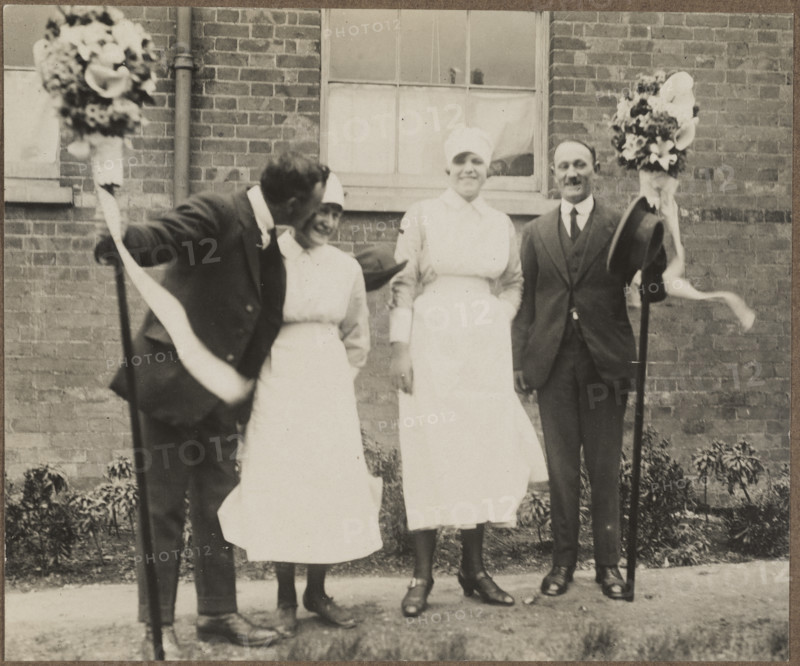 Two men holding tutti poles, with two women during the Hocktide Festival in Hungerford, 1925-35.  Creator: George R Long.