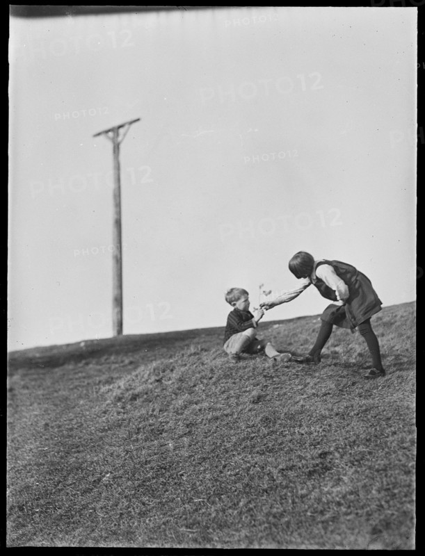 Two children playing in front of Combe Gibbet, Inkpen Hill, Inkpen, West Berkshire, 1925-1935. Creator: George R Long.