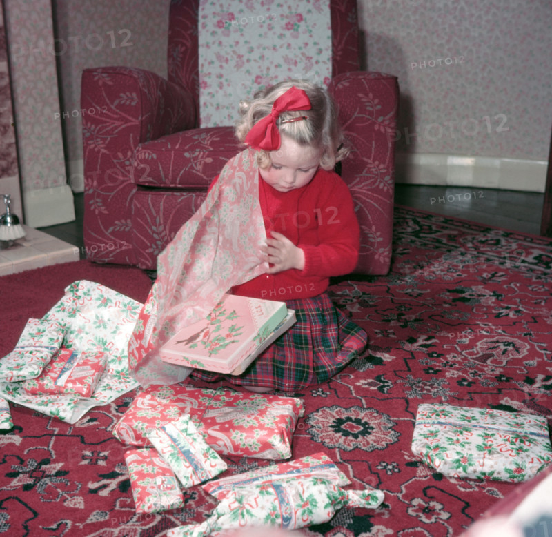 Girl opening her Christmas presents, c1955.  Creator: Arthur Charles Kirby Ware.