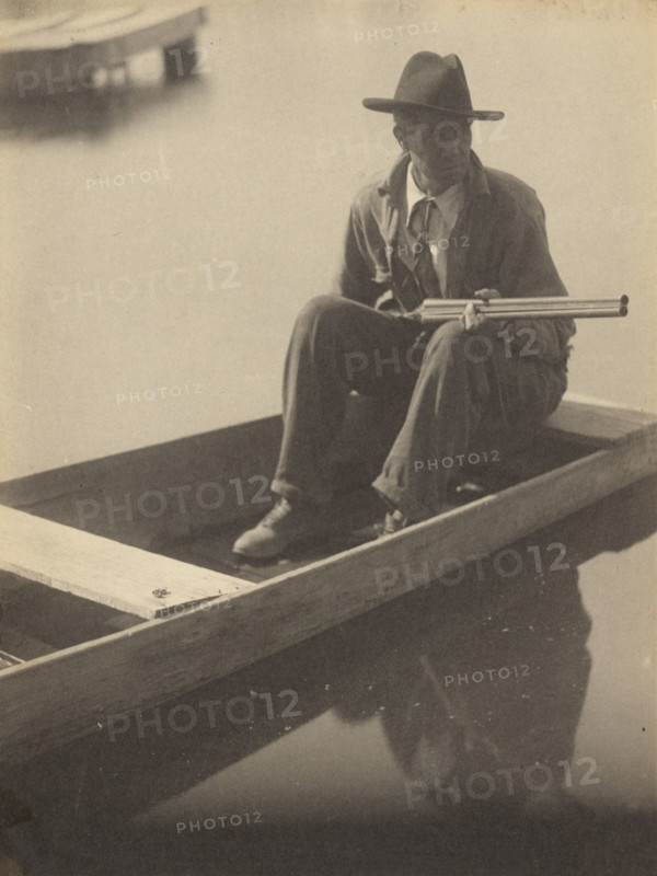 Black Man in Flat Boat, Holding Shotgun, 1929-1930. Creator: Doris Ulmann.