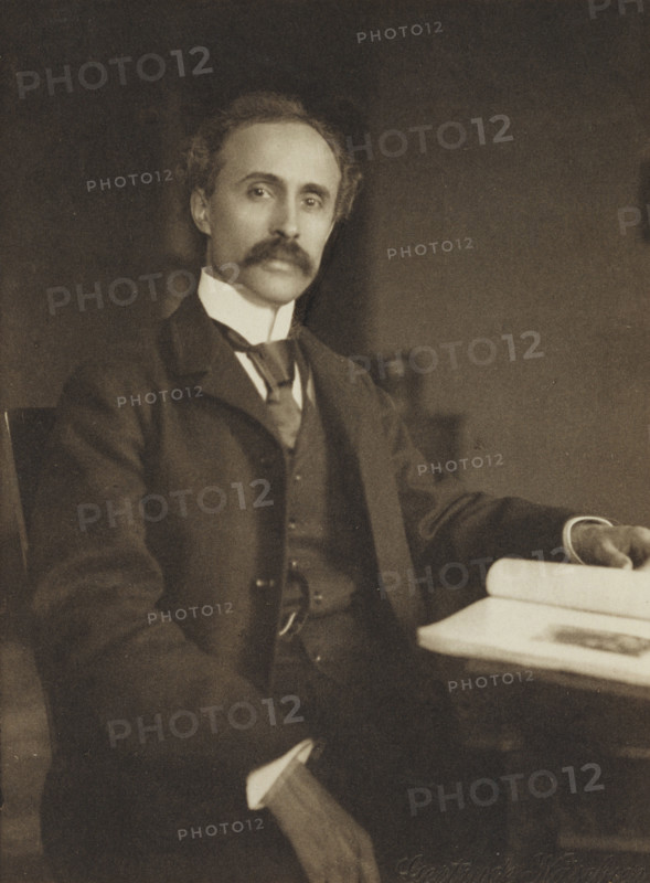 Man seated with table and book, 1896-1898. Creator: Gertrude Kasebier.