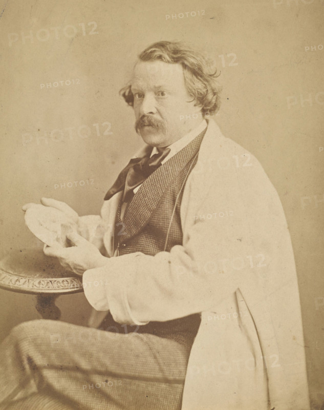 Self-portrait holding medallion commemorating his deceased mother, 1860-1861. Creator: Nadar.